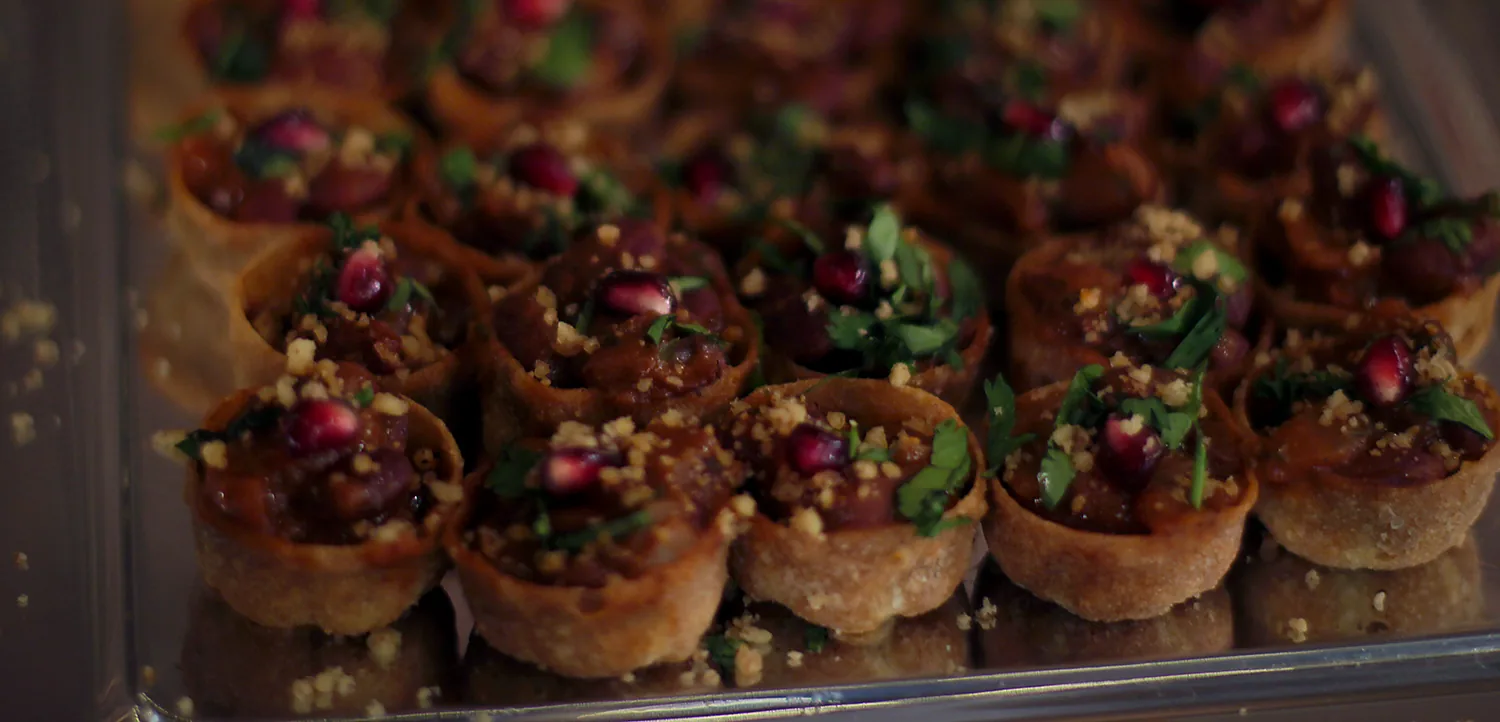 A spread of Georgian catering — lobio cups topped with pomegranate and walnut