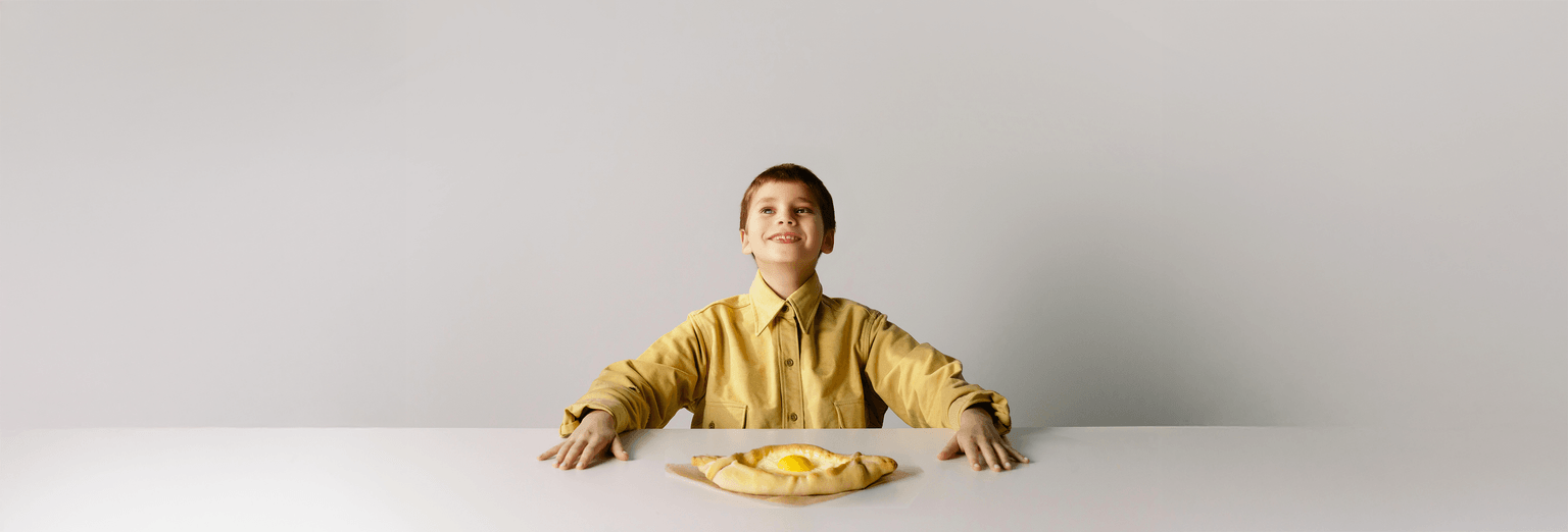 Khachapuri in front of a very hapy kid